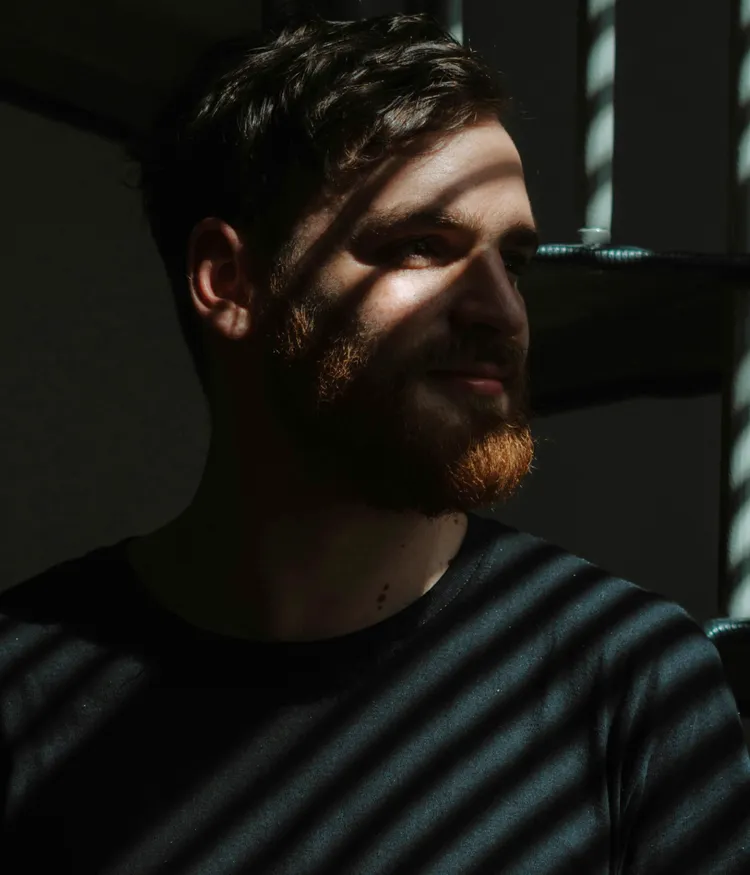 Ein Mann im Schatten und Licht einer streifenartigen Struktur