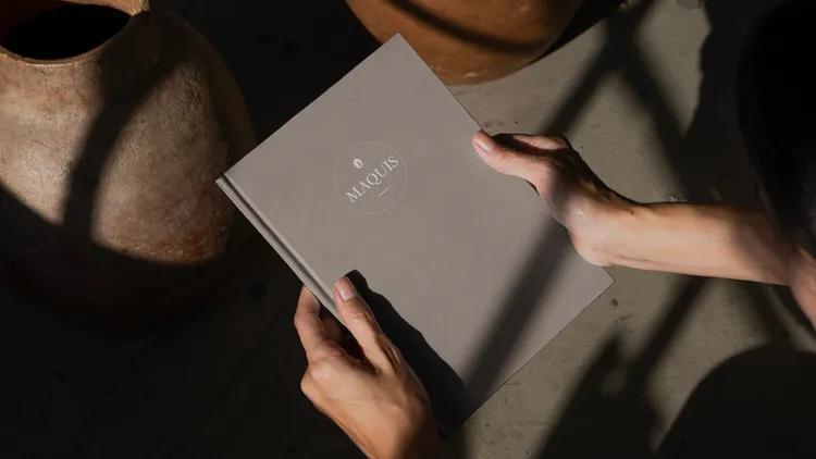 Zwei Hände, die das Maquis-Menü halten.