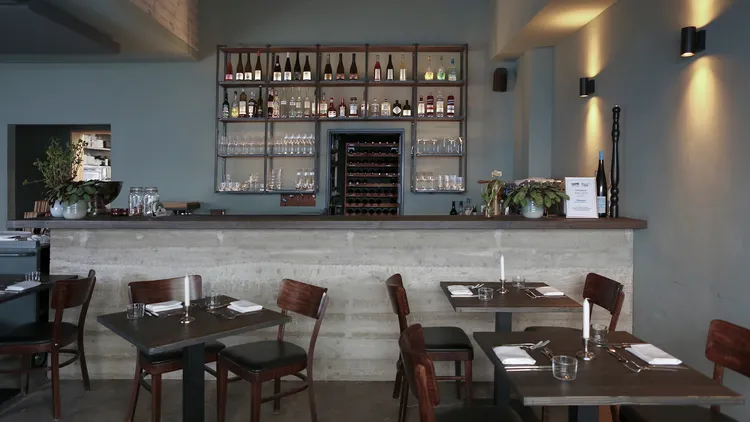 Ein Blick durch das Restaurant Maquis auf die gemütlich beleuchtete Bar